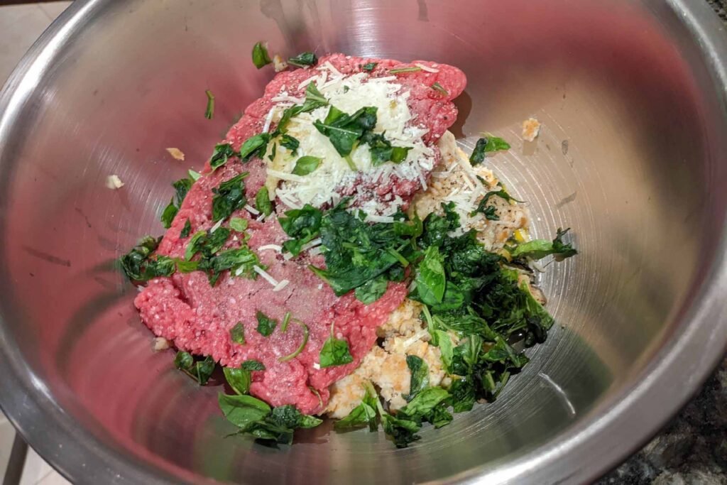 Mixing bowl filled with Italian meatball ingredients