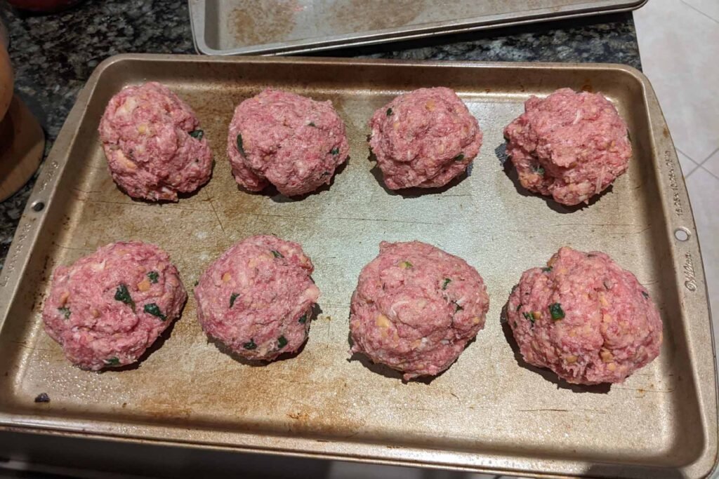 Raw meatballs on a baking sheet