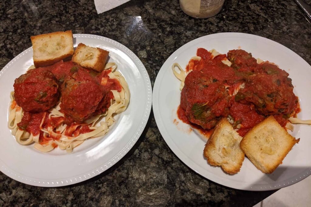 Two plates of homemade fettuccine and meatballs