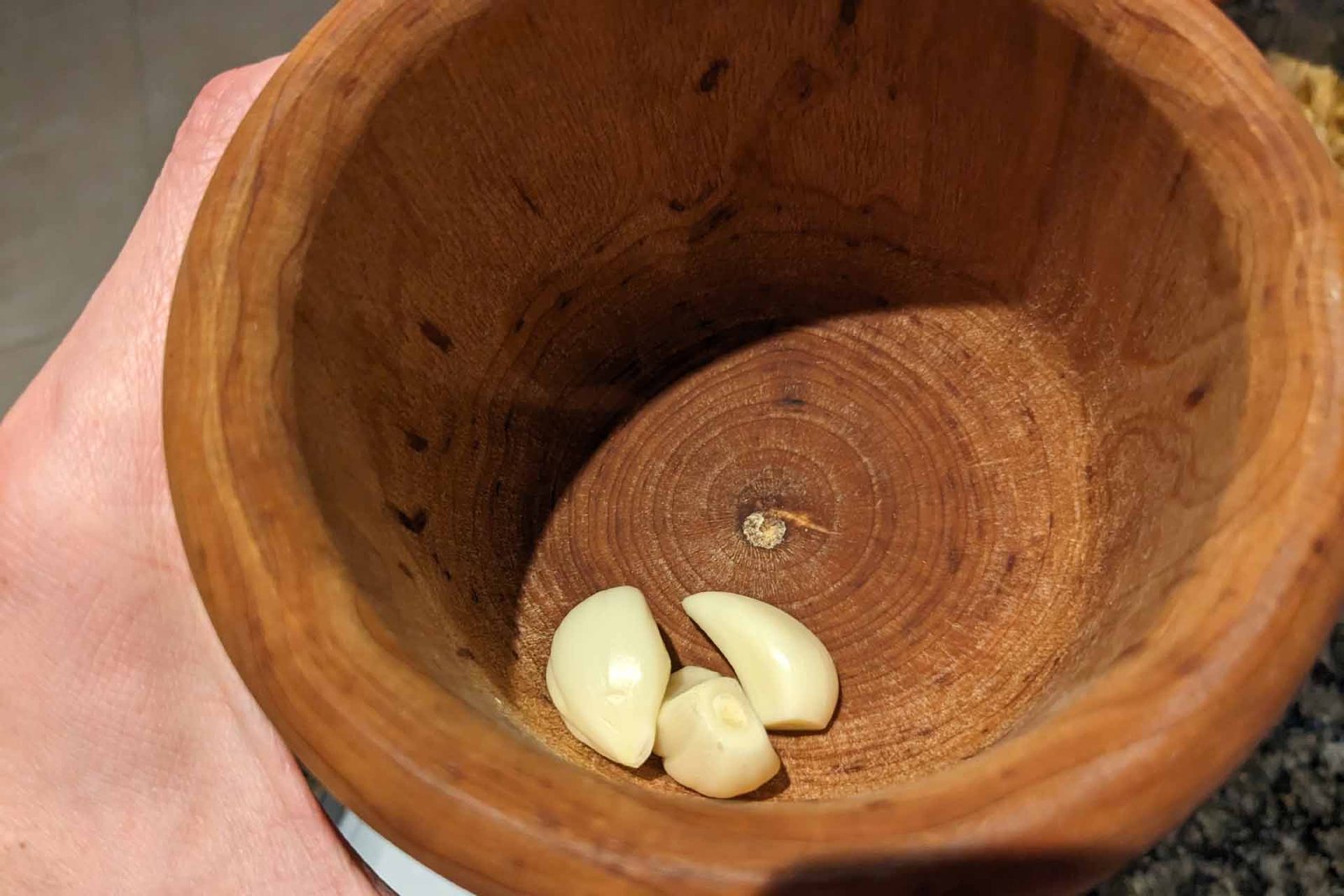 Whole garlic cloves in a wooden mortar (bowl)