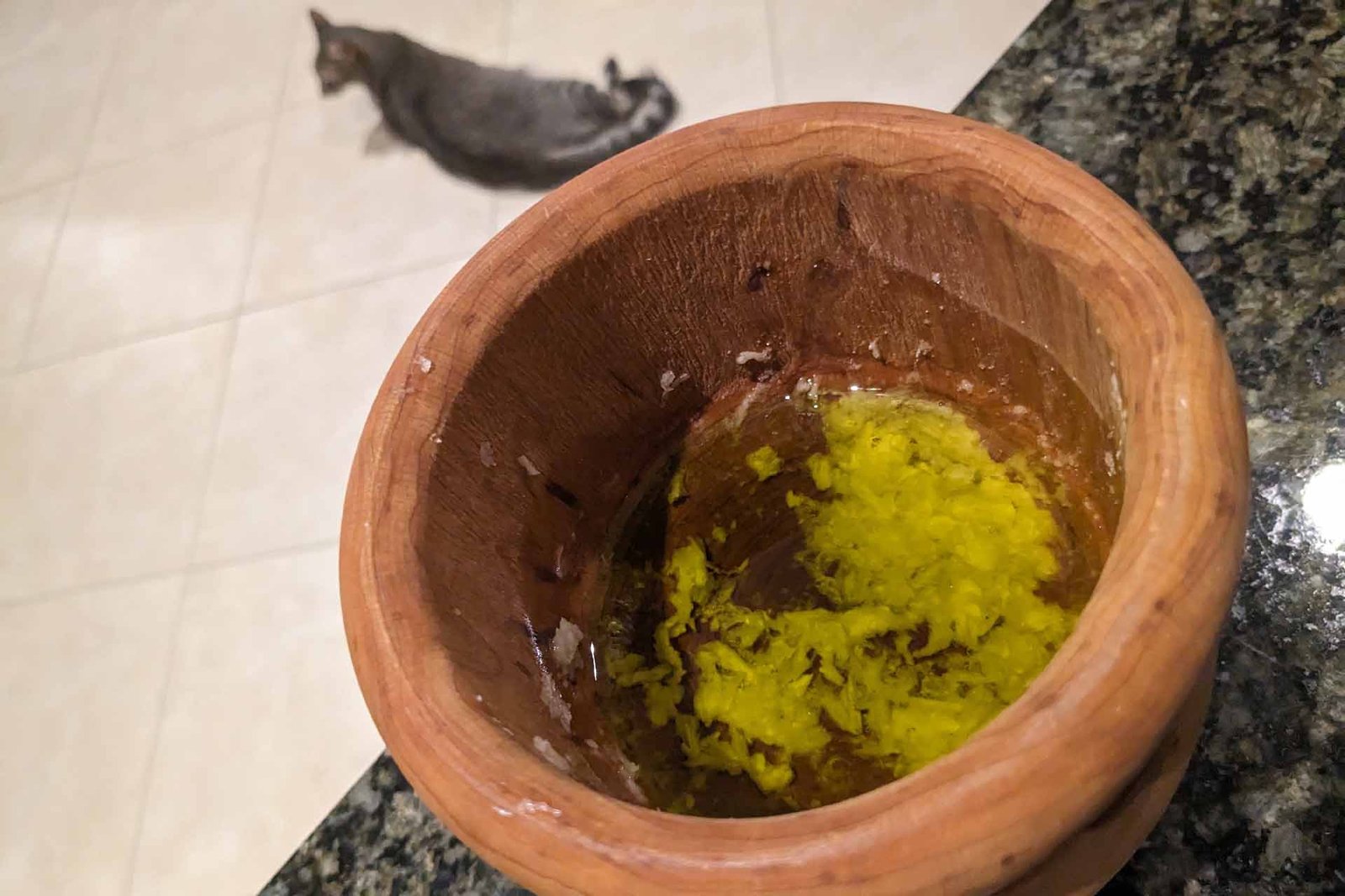 Garlic pulp and olive oil in a wooden mortar