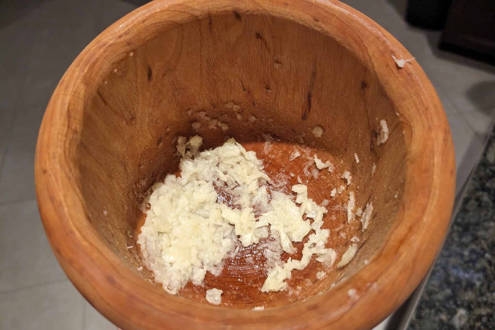 Garlic pulp mixture in a wooden mortar