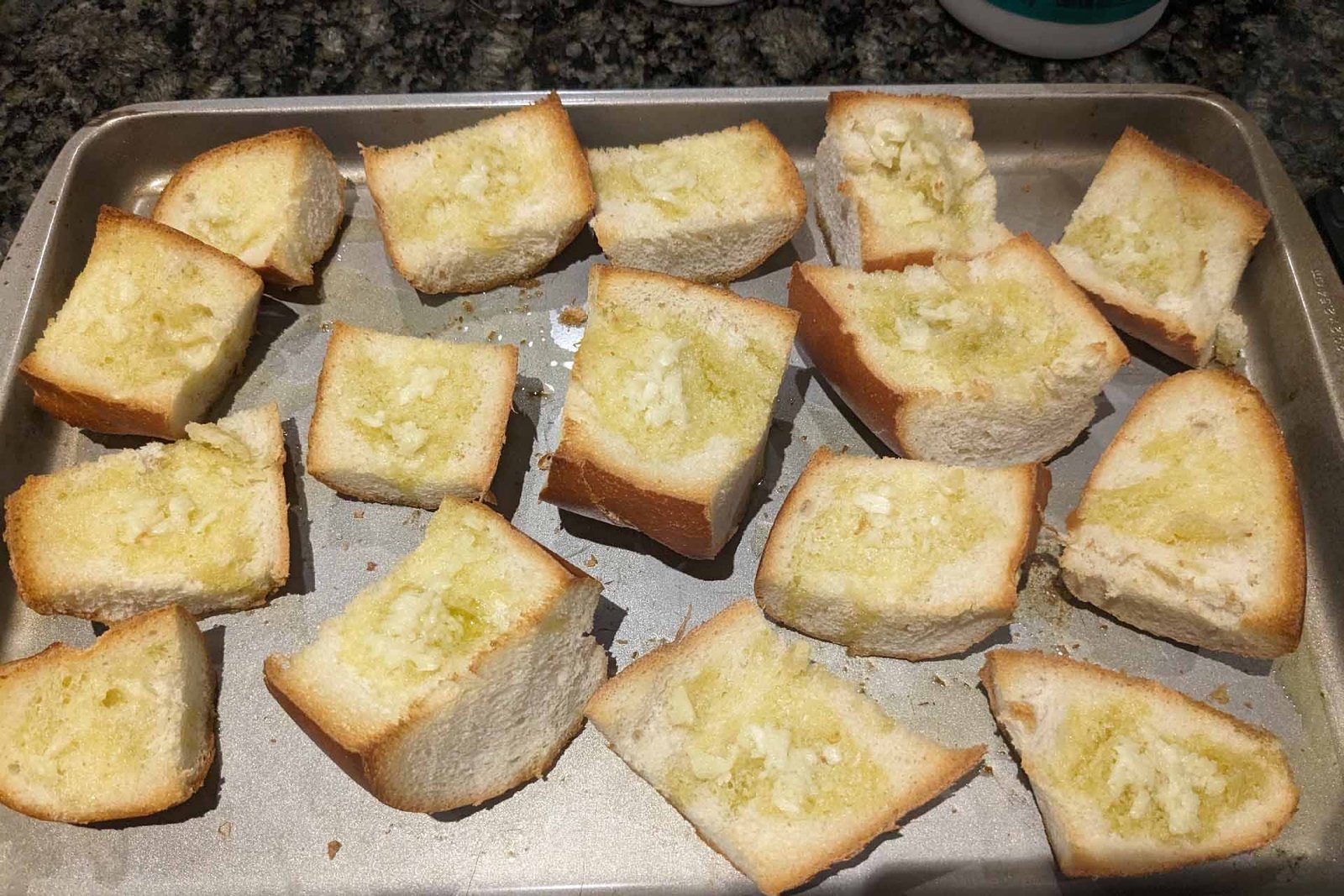 Toasted garlic bread pieces on a baking sheet