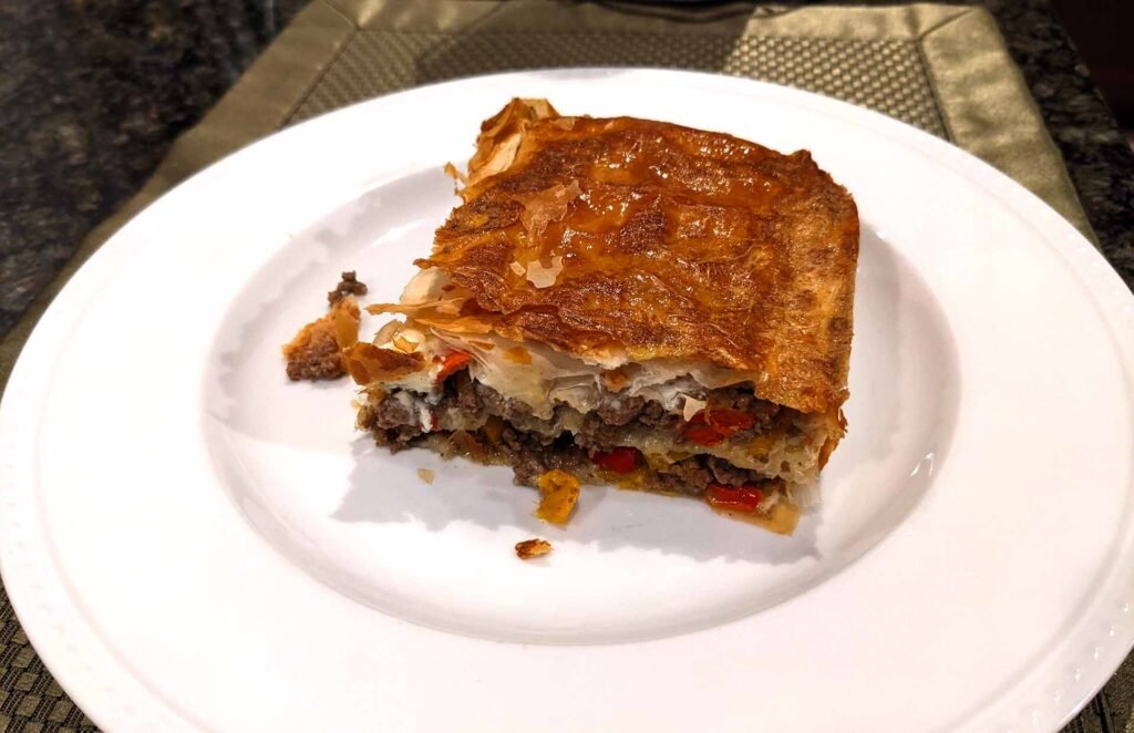 Slice of golden brown Turkish Borek meat pie