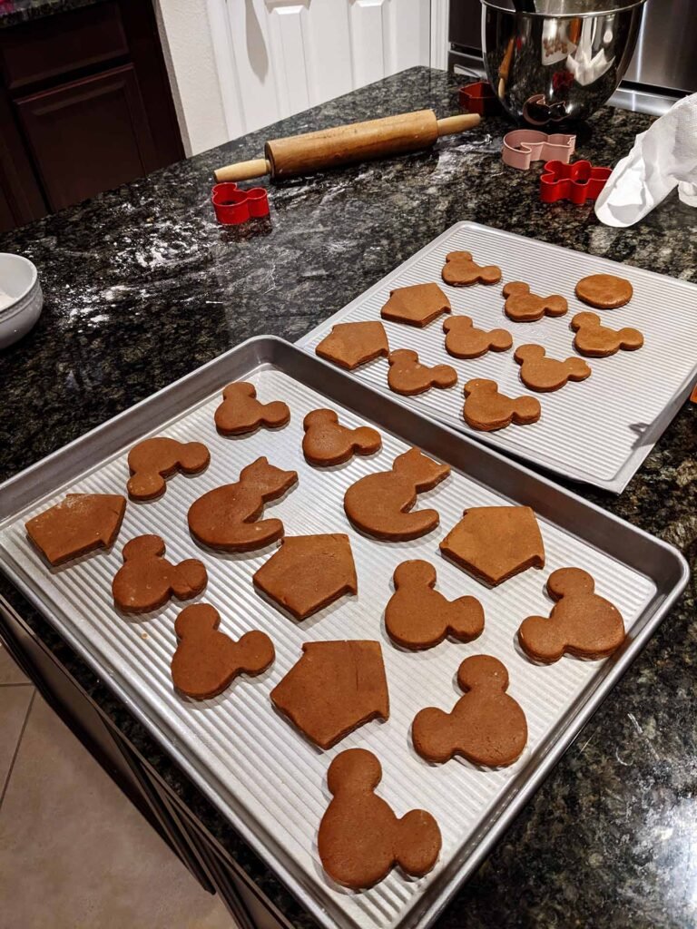 Gingerbread cookie dough cut out in shapes and laid out on baking sheets