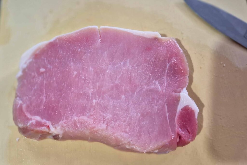 Raw pork cutlet on a cutting board